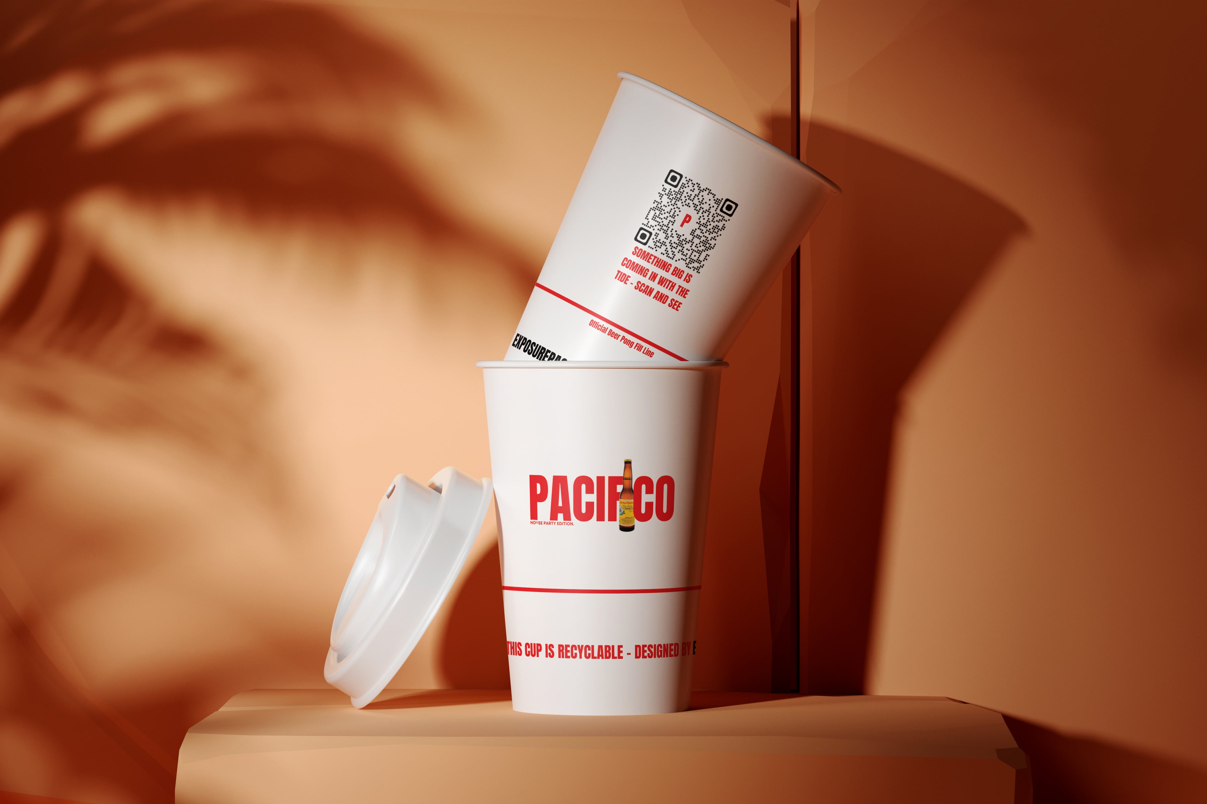 Two paper cups with 'Pacífico' branding on a wooden surface with an orange background