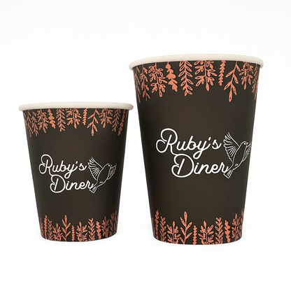 Two custom paper cups with 'Ruby's Diner' branding and leaf pattern on a white background